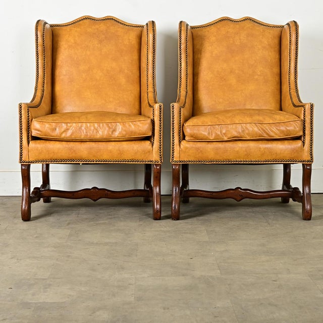 Dimensions: 38 ¾” H x 26 ⅞” W x 30 ½” D A wonderful pair of 20th century Os de Mouton style wingback chairs, by American...