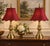 A matched pair of turned solid-brass table lamps with stepped circular bases, tapered necks, and sculptural fluted urn...