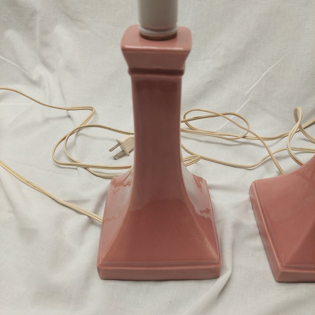 This beautiful mid-century modern lamp pair is made of pastel pink ceramic with white metal elements and have matching...