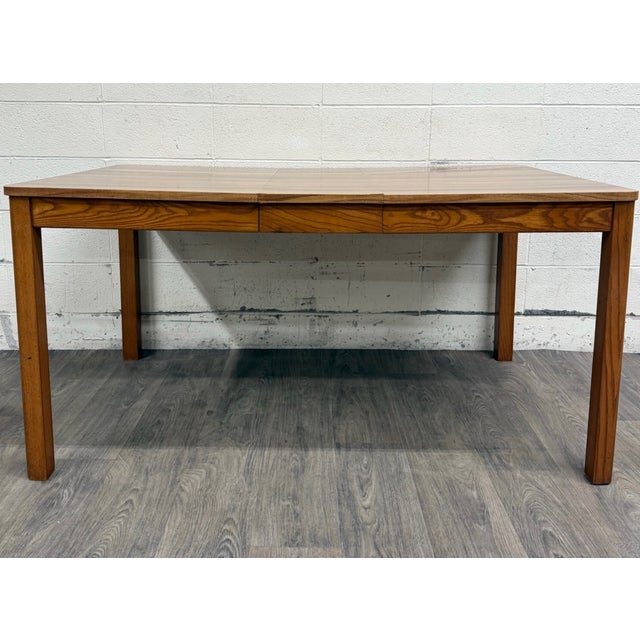 This a gorgeous Mid-Century Modern (MCM) dining table featuring a richly patterned wood-grain laminate top with warm...