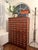 A striking vintage apothecary-style library card catalog cabinet featuring 72 individual wooden drawers, each finished...
