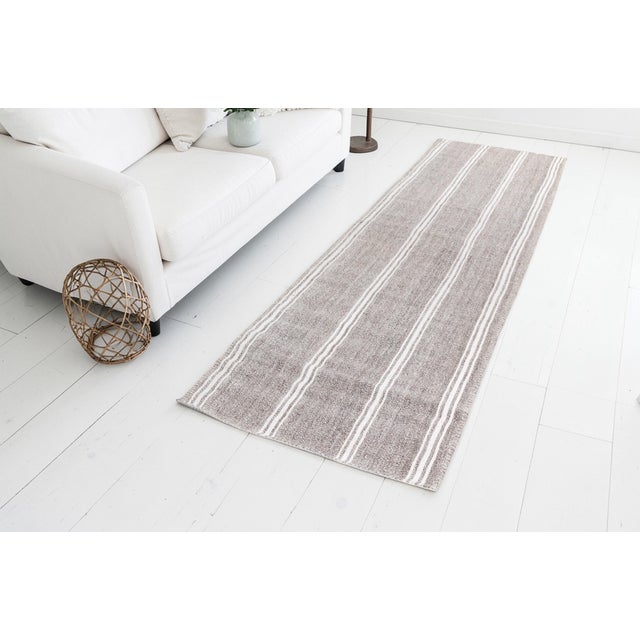 This is a vintage Turkish Oushak rug from the Mid 20th Century. The piece was hand-knotted.