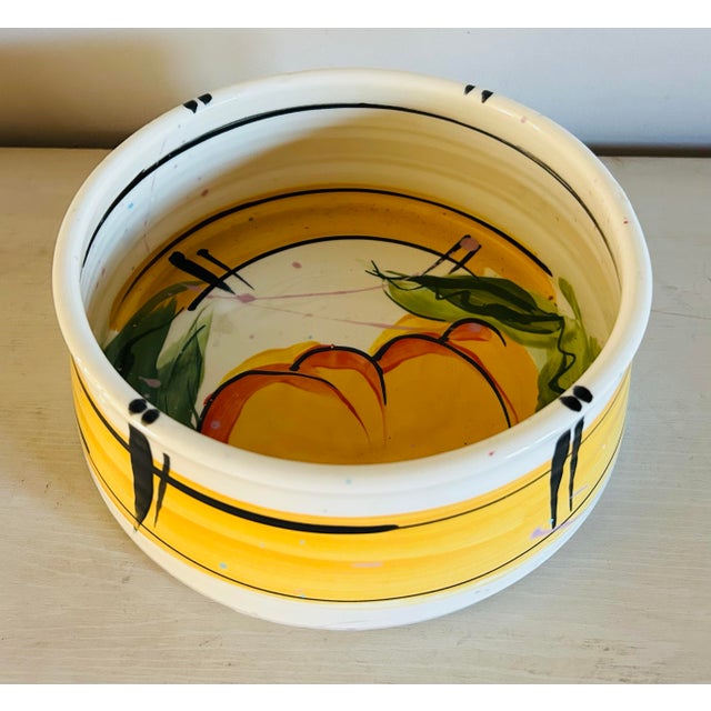 Original studio pottery serving bowl by artist Donna Toohey. Features abstract painting of amber colored peaches with...