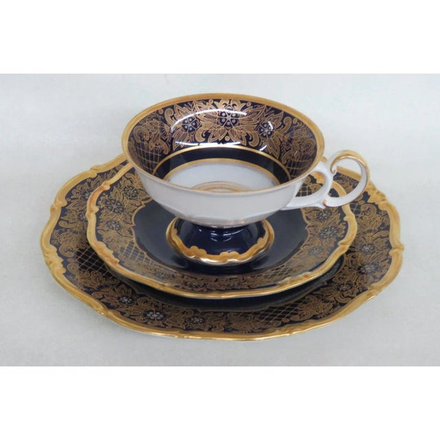 This lovely set of a tea cup, saucer, and dessert plate is made of bone china. This set is stamped as being made by Weimar...