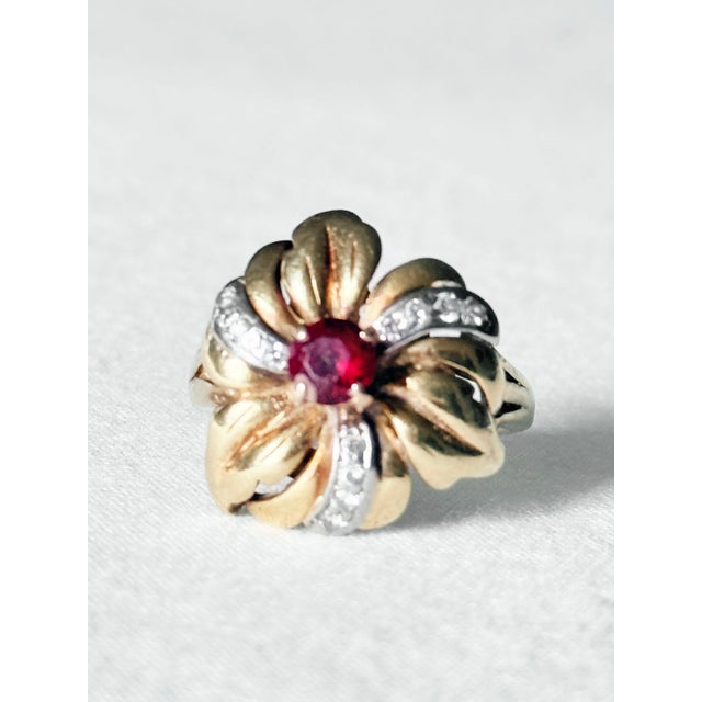 Vintage 18K yellow gold flower ring featuring a sculpted plumeria style blossom with overlapping petals, centered by a...
