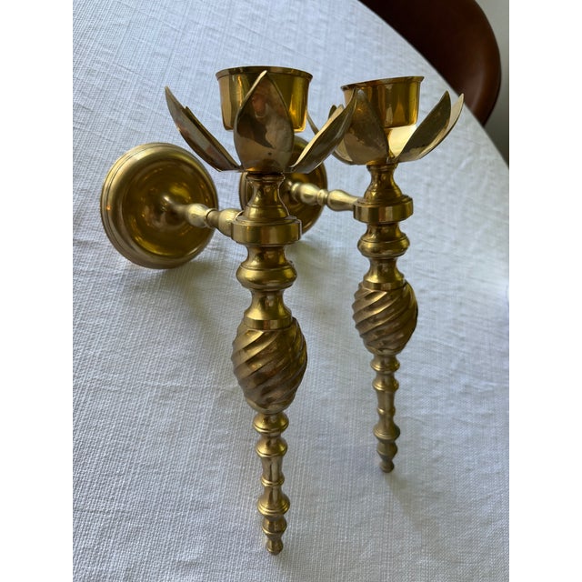 Elegant pair of vintage solid brass wall-mounted candle sconces featuring sculptural lotus flower cups and beautifully...
