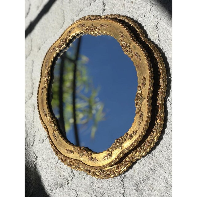 Mid-century Italian Baroque-style wall mirror, beautifully hand-carved and finished in original gilt. The design reflects...