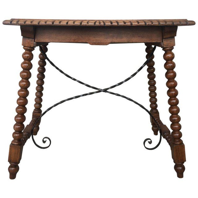 About 19th century Spanish farm table with iron stretchers, hand carved top and drawer. An unusual form with nice shiny...