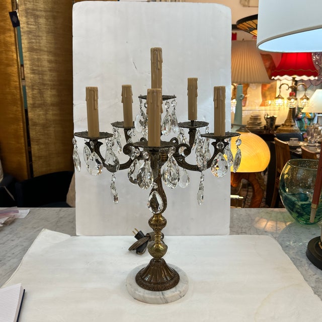 Gorgeous tabletop candelabra fashioned in bronze with dangling faceted crystals and a round Carrara marble base. It has...