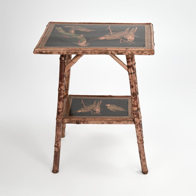 Charming 19th century English table or stand handcrafted in burnt bamboo featuring two tiers of decoupaged parrots.