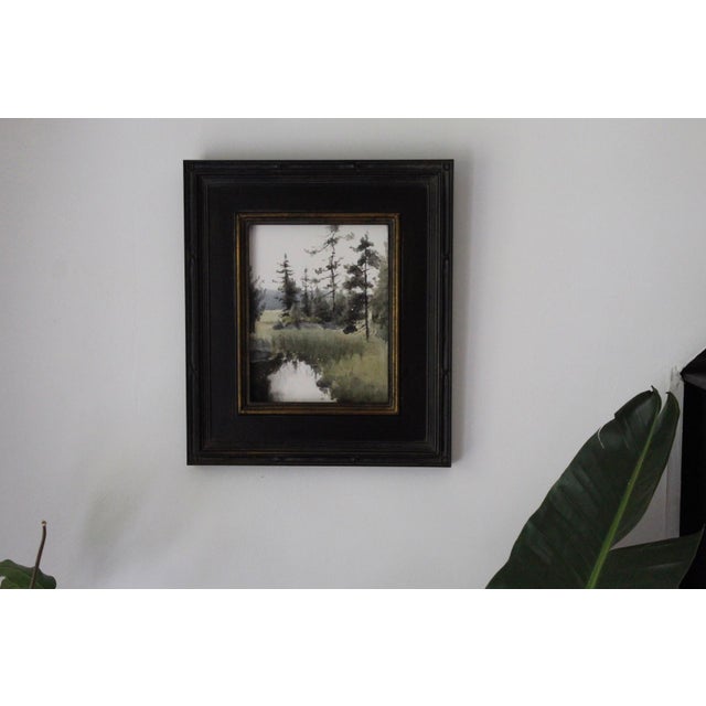 This watercolor on paper captures a serene natural landscape, featuring a tranquil meeting place by a reflective body of...