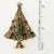 Vintage Christmas tree pin set with red, green, and amber rhinestones. Metal is gold plated with an antiqued finish....