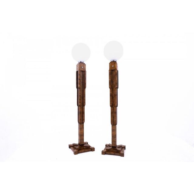 A pair of Art Deco floor lamps, Poland, circa 1940. Wooden lamp bases with a geometric form characteristic of the Art Deco...