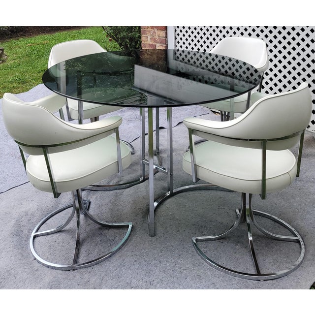 This space-age chrome and white vinyl dining set from groovy MCM brand Cal-Style is comfortable, functional, and gives off...