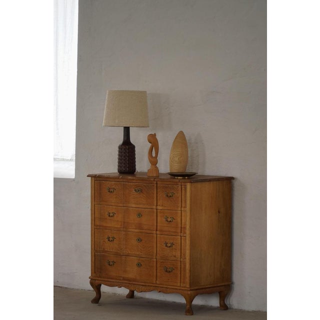 A characterful chest of drawers in the style of Henning (Henry) Kjærnulf, crafted in oak and made in Denmark in the 1960s....