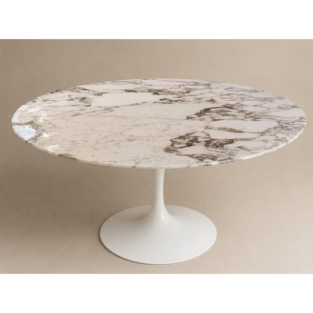 Circular dining table, "Tulip" model, created in 1957. Top in white Calacatta marble with beige and gray veining and a...