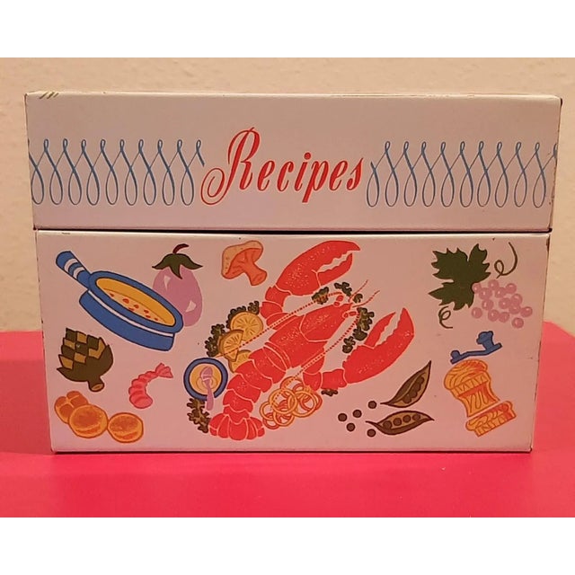 Metal recipe box, excellent condition. Bright colored graphics and stamped OHIO ART. Main feature cooking utensils,...