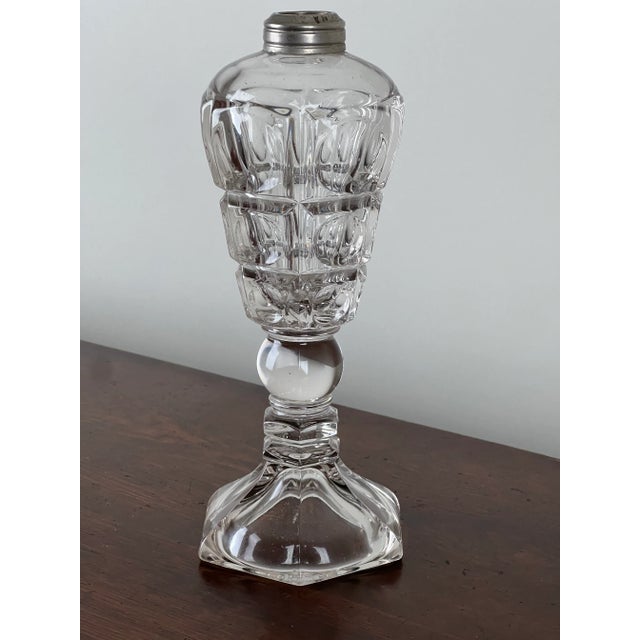 A beautiful mid-19th century pressed glass whale oil lamp, likely produced by the Westmoreland Glass Company. The lamp...