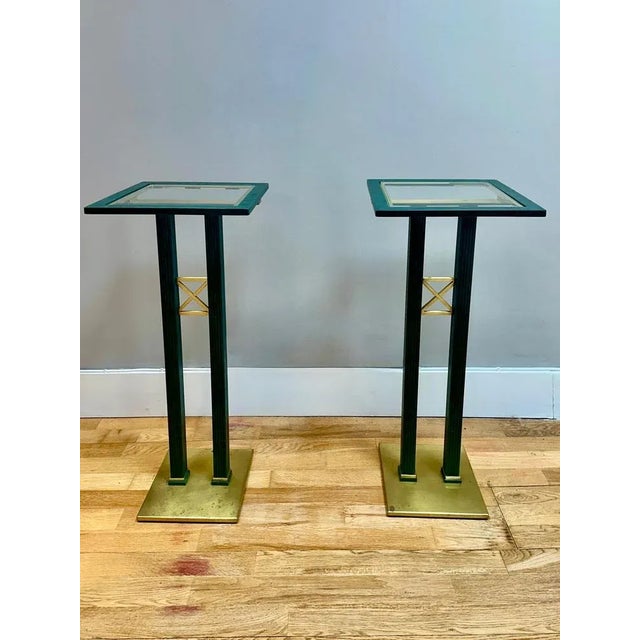 A pair of tall pedestals in bronze verdigris patinated brass with glass tops and polished brass base and assents. By the...