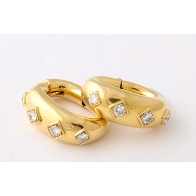 4 Bezel-set diamonds. Marked David Webb 18kt.Chic & elegant. High-style hoops with 4 bezel-prong settings. Earrings with a...