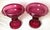 A pair of 19th century hand blown cranberry glass rolled edge footed bowl form compotes. The glass with delicate engraved...