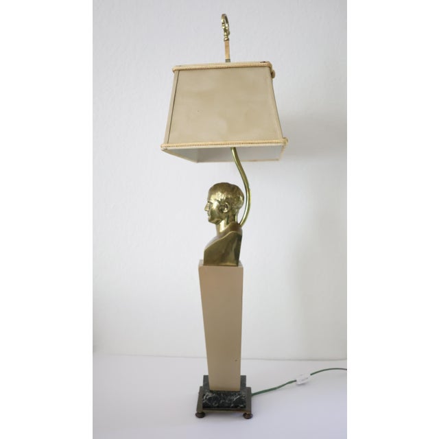 This striking mid-century brass table lamp features a bust of a Roman or Napoleonic figure mounted on a tall rectangular...