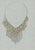 Hand-drawn necklace design with a broad bib of overlapping elongated teardrop/leaf forms, accented with small gold floral...