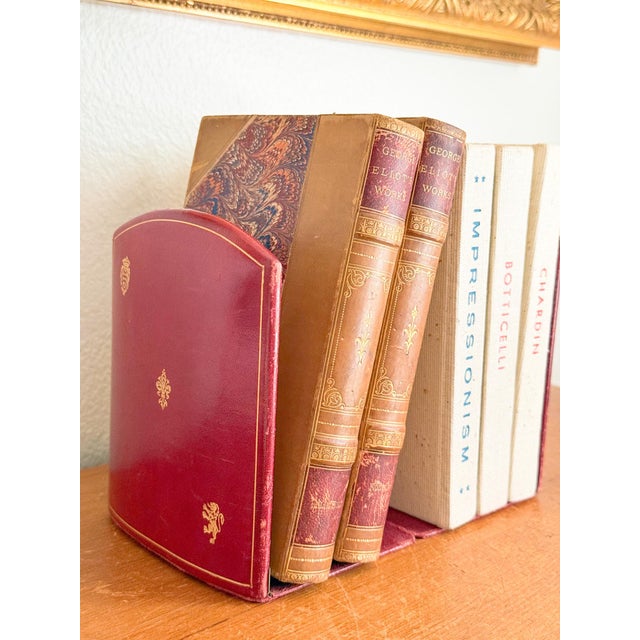 Fantastic pair of red leather and gilt folding bookends with brass hinges. Fleur de Lis and Lion markings indicate...
