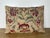 A decorative pillow crafted from a beautifully printed linen textile featuring a lively floral and foliate motif in rich,...