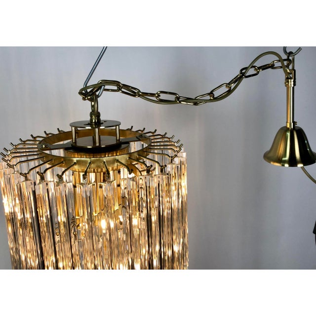 Large cascading Murano glass chandelier from the 1980s. Composed of a gilded brass frame from which hang 70 triangular...