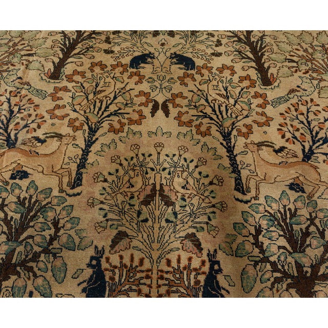 An early 20th century antique Persian Tabriz carpet, the caramel field with a lush allover design of naturalistic animals...