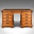 This is an antique single-piece show desk. An English, oak and leather pedestal desk for central room placement by...
