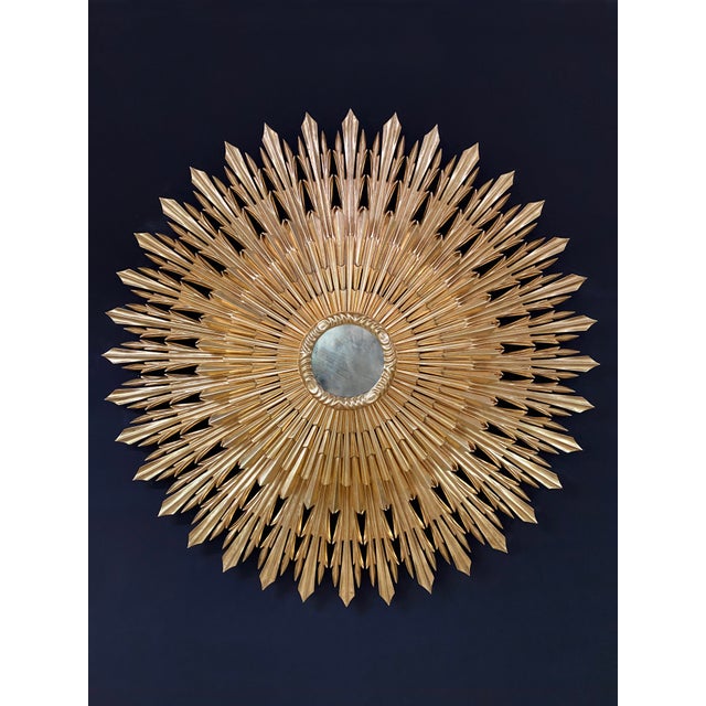 Magnificient mid-century modern style sunburst golden mirror. This exquisite piece was entirely hand-carved and features...