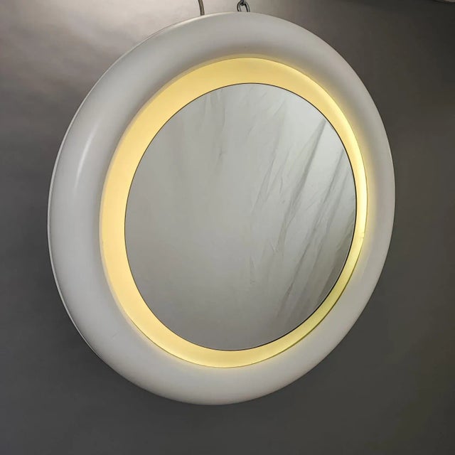 Round backlit mirror in white lacquered wood. Period: 1970s Material: White lacquered wood with neon backlighting...