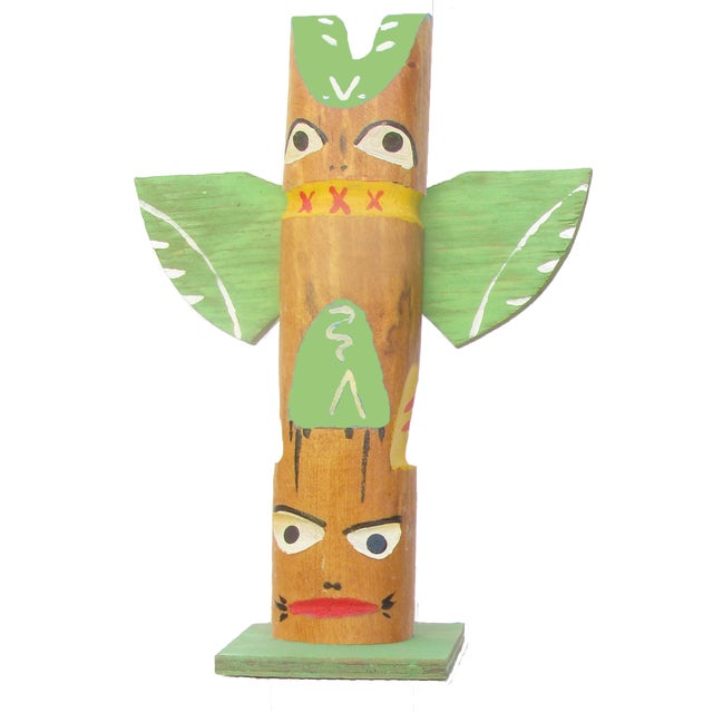 Pair of whimsical and colorful artisan-made painted wood totem pole sculptures believed to be from the 1960s. Vintage...