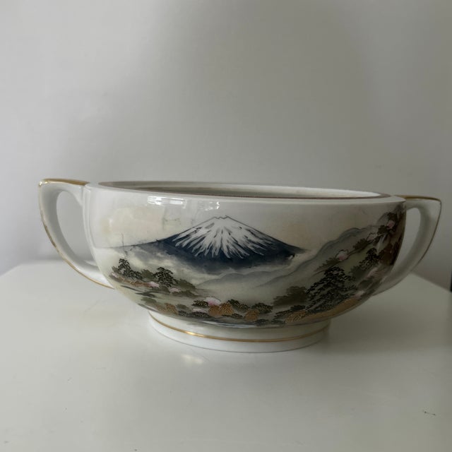 A striking vintage Japanese Kutani porcelain bowl featuring a hand-painted landscape centered on snowcapped Mount Fuji....