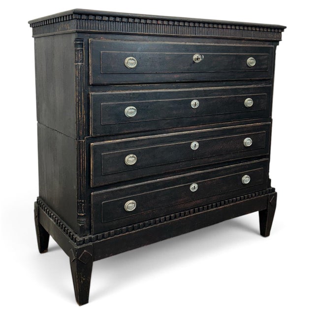 Antique Gustavian chest of drawers in black. The piece consists of two stacked pieces. Beneath the top is a wide molding...