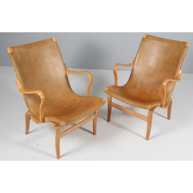Bruno Mathsson pair of Eva lounge chair with patinated saddle leather Frame in beech. Made by Karl Mathsson. This piece is...