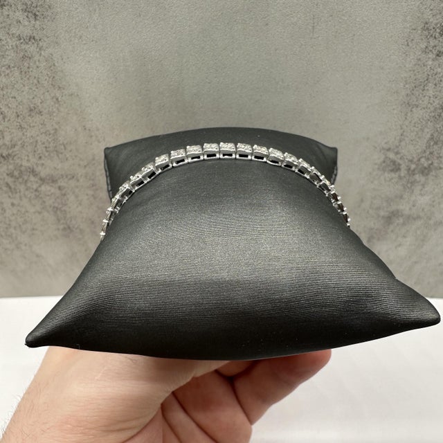 This elegant diamond tennis bracelet in sterling silver features 1 carat total weight of natural IJ, I quality round...