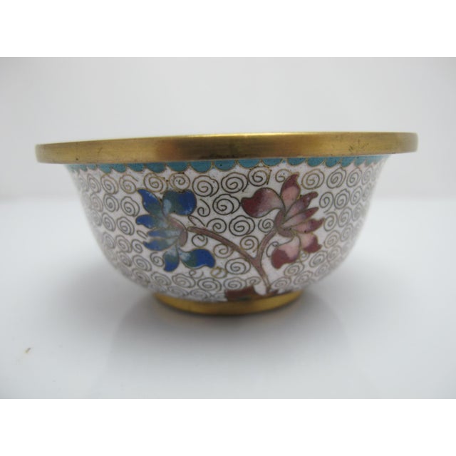 Pair of small vintage Chinese cloisonné bowls. Each features an intricate enamel-over-brass design in white with clouds,...