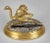 Gilded bronze inkwell in the form of a running ostrich on a ebonized rocky surface, mounted on a bronze oval stepped base,...