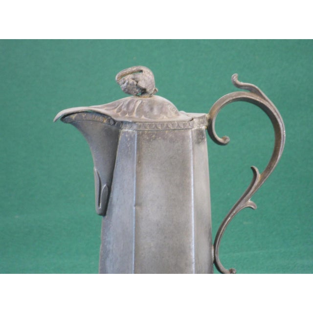 This 18th-19th century American pewter syrup jug with lid creamer is a rare and handmade piece from the United States. The...