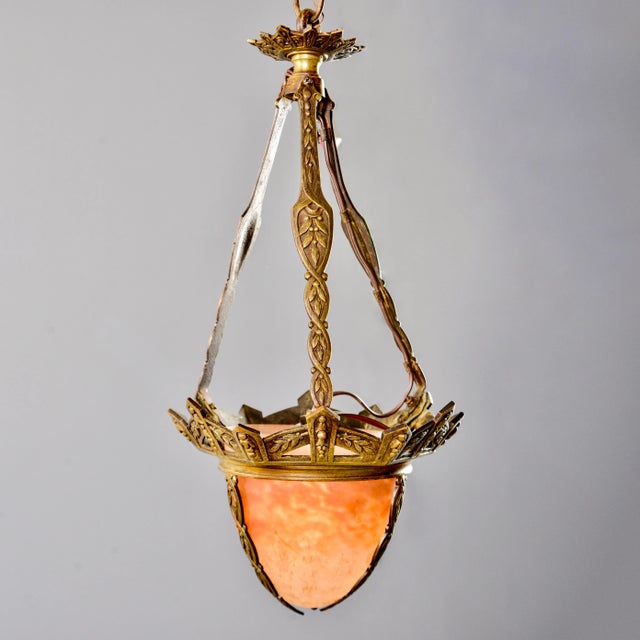 Small French Art Deco pendant has decorative bronze frame and chain with mottled Muller Freres glass globe, circa 1930s....