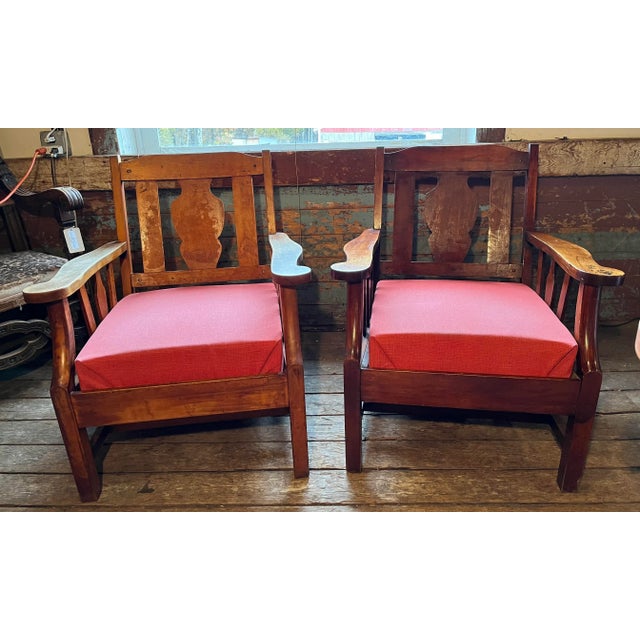 Pair of maple oversized armchairs with cushions. The chairs have imperfections in the finish. Structurally they are in...