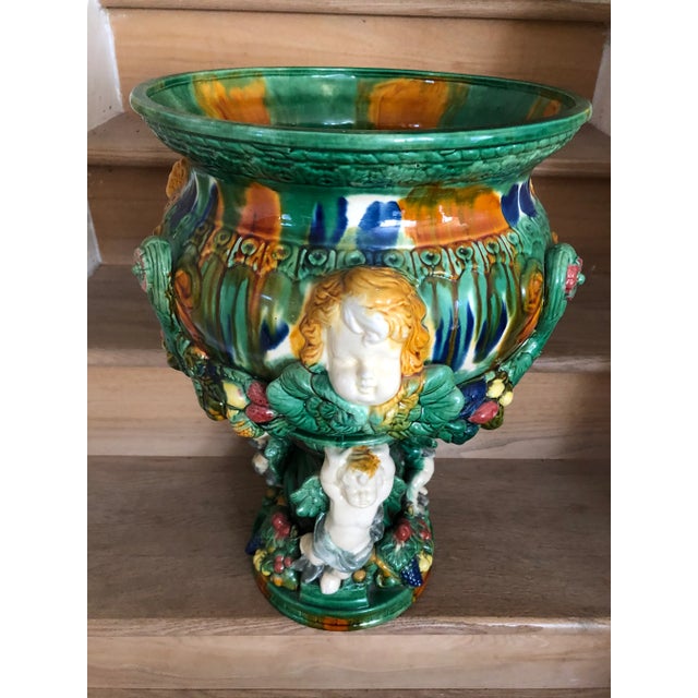 Large glazed pottery pedestal planter jardiniere in cherub design fruit pedestal bowl. Glazed inside out. H 20.25" across...