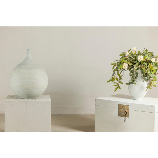 This large late 20th-century artisan ceramic vase features a rounded, bulbous body with a narrow elongated neck and small...