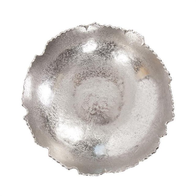 This unique bowl is fashioned from metal and features "torn" edges. It is finished with a bright metallic silver. Console...