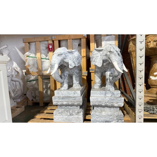 A magnificent pair of solid marble elephant sculptures, each meticulously hand-carved to capture the power, grace, and...
