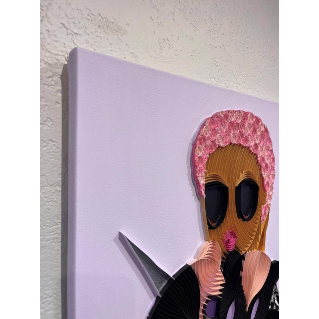 Plushie X features a vibrant composition that intertwines paper strips, fabric, and acrylic to create a textured portrayal...