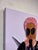Plushie X features a vibrant composition that intertwines paper strips, fabric, and acrylic to create a textured portrayal...